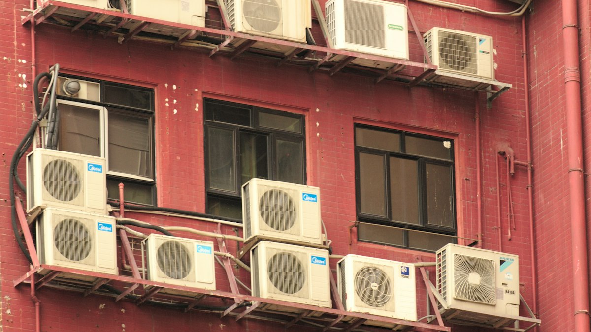 Rows of AC outdoor units mounted on a red building