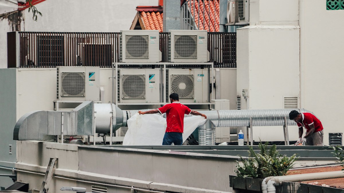 Technicians working on rooftop air conditioning units