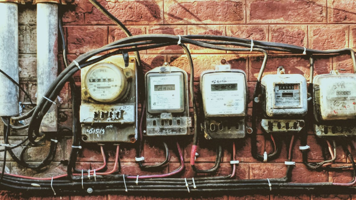 Row of electricity meters and wiring on a brick wall